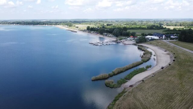 Duże spokojne jezioro z błękitną wodą w wakacyjny ciepły dzień
