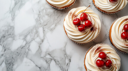Cupcakes with whipped cream and cherries on marble background. Copy space.	