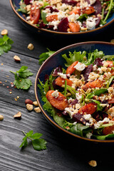 Warm baked carrots and beetroot salad with feta cheese and roasted hazelnuts