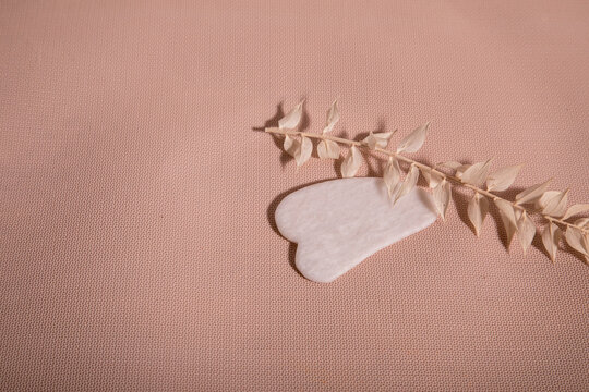 Tool for massage guash on a peach background. Facial care device and relaxation concept. Facial care