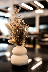 Dried flowers or dried flowers in a white ceramic vase. Minimalist decoration on the table.