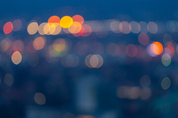 Defocused city scape with colorful defocused city lights glowing in the distance