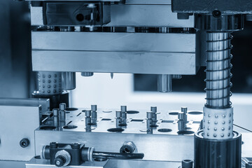 The metalworking process by progressive die in the light blue scene.