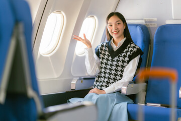 Asian woman sitting on airplane and looking out window, travel concept, tourism, business