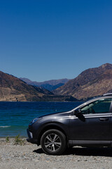 Fototapeta premium Car by the Scenic Lake with Mountain Backdrop