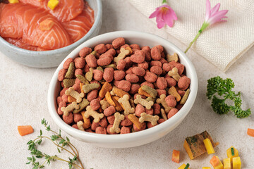 Dry dog ​​food is pellets in a white cup,