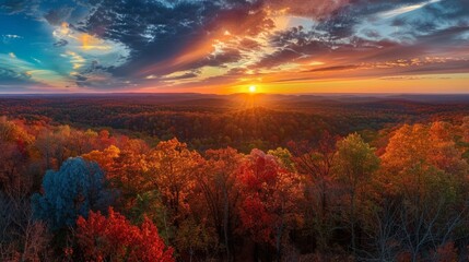 A breathtaking view of a vibrant autumn sunset over a forested landscape.