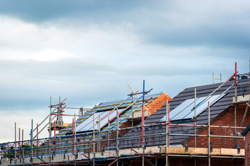 Fototapeta premium Photovoltaic solar panels on the roof of new built house in england uk. The concept of a sustainable environment, construction