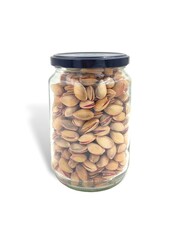 Photo of a glass jar filled with pistachios from Aegina, Greece, isolated on white background.