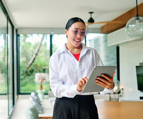 Portrait of asian real state agent female standing in new property apartment or house, or a businesswoman in office holding tablet