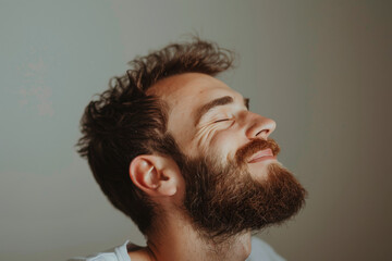 Obraz premium A close up of a man with beard and closed eyes looking to a side