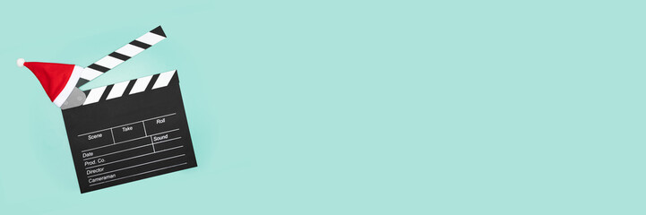 Obraz premium Cinema clapper board christmas santa hat, video clapboard action, winter sale, entertainment industry discount, holiday decoration