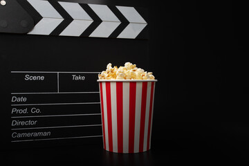 Popcorn bucket and Cinema clapper board, film industry treat, cinema night snack, pop corn and clapboard fun