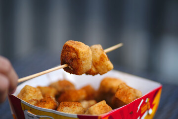 a cardboard box filled with fried crispy tofu
