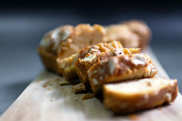 Baked peanut butter cake with nuts on wooden cutting board. Healthy and easy bake from air fryer. Selective focus.