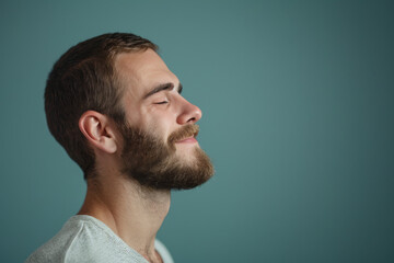 Obraz premium A close up of a man with beard and closed eyes looking to a side