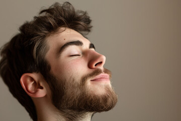 Obraz premium A close up of a man with beard and closed eyes looking to a side