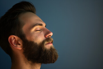 Obraz premium A close up of a man with beard and closed eyes looking to a side