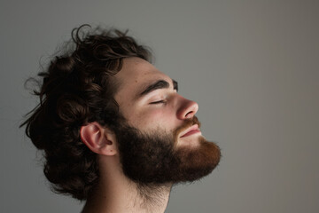 Fototapeta premium A close up of a man with beard and closed eyes looking to a side