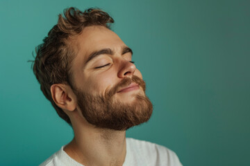 Obraz premium A close up of a man with beard and closed eyes looking to a side