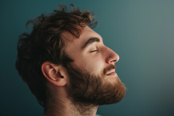 Obraz premium A close up of a man with beard and closed eyes looking to a side