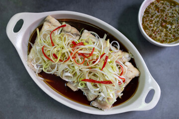 A delicious and healthy steamed fish dish with a light soy sauce and ginger sauce.