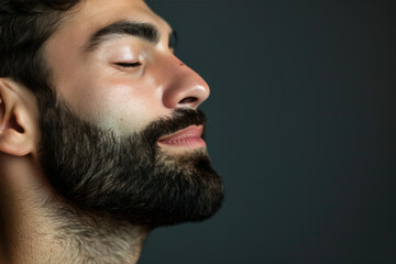 Obraz premium A close up of a man with beard and closed eyes looking to a side