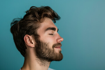 Obraz premium A close up of a man with beard and closed eyes looking to a side