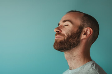 Obraz premium A close up of a man with beard and closed eyes looking to a side