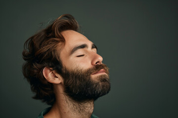 Fototapeta premium A close up of a man with beard and closed eyes looking to a side