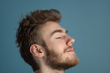 Obraz premium A close up of a man with beard and closed eyes looking to a side