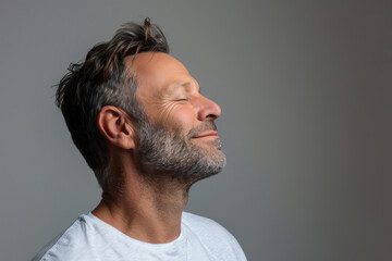 Obraz premium A close up of a man with beard and closed eyes looking to a side