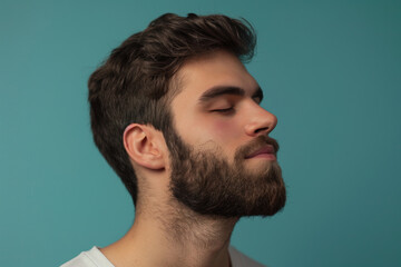 Fototapeta premium A close up of a man with beard and closed eyes looking to a side