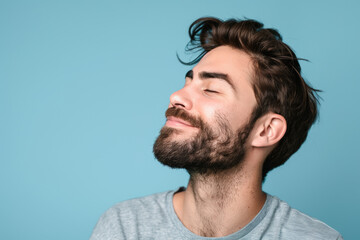 Obraz premium A close up of a man with beard and closed eyes looking to a side