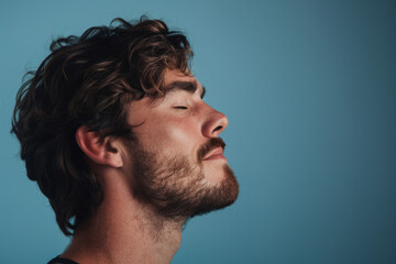 Obraz premium A close up of a man with beard and closed eyes looking to a side