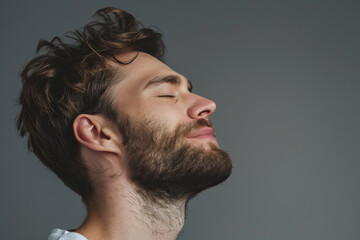 Fototapeta premium A close up of a man with beard and closed eyes looking to a side