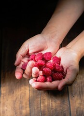 hands with handful of raspberries