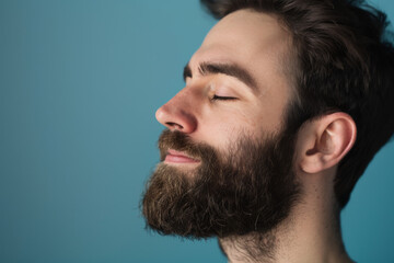 Fototapeta premium A close up of a man with beard and closed eyes looking to a side