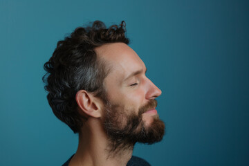 Fototapeta premium A close up of a man with beard and closed eyes looking to a side