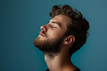 Fototapeta premium A close up of a man with beard and closed eyes looking to a side