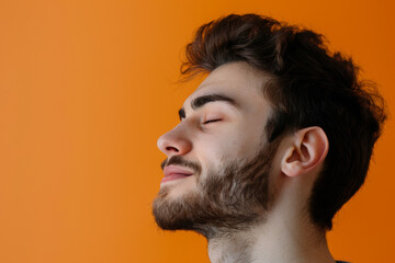 Obraz premium A close up of a man with beard and closed eyes looking to a side