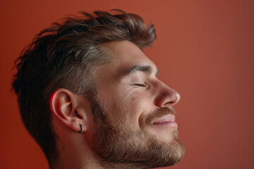 Obraz premium A close up of a man with beard and closed eyes looking to a side