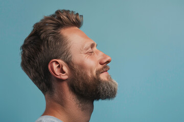 Fototapeta premium A close up of a man with beard and closed eyes looking to a side