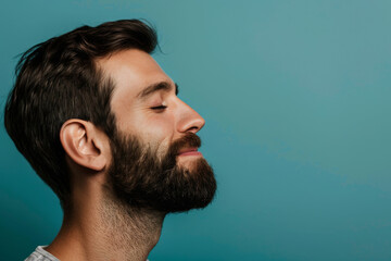 Fototapeta premium A close up of a man with beard and closed eyes looking to a side