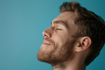 Obraz premium A close up of a man with beard and closed eyes looking to a side