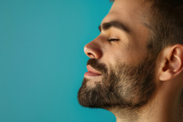 Obraz premium A close up of a man with beard and closed eyes looking to a side