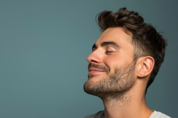 A close up of a man with beard and closed eyes looking to a side