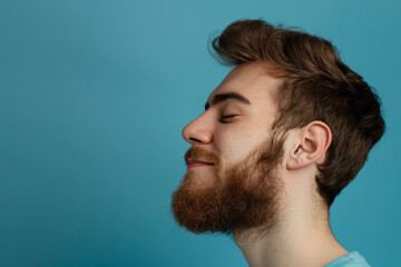 Fototapeta premium A close up of a man with beard and closed eyes looking to a side