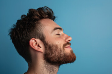 Obraz premium A close up of a man with beard and closed eyes looking to a side