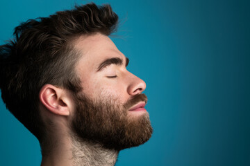 Fototapeta premium A close up of a man with beard and closed eyes looking to a side